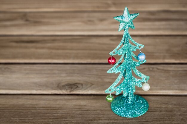 Foto pequena árvore de natal de metal verde na mesa de madeira