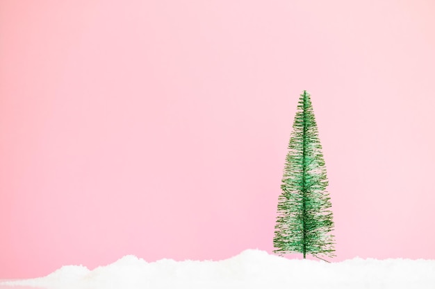 Pequena árvore de natal em fundo rosa