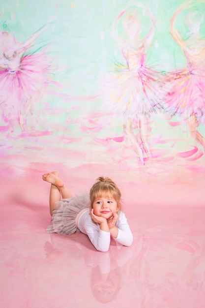 Pequeña bailarina linda haciendo ejercicios en el estudio