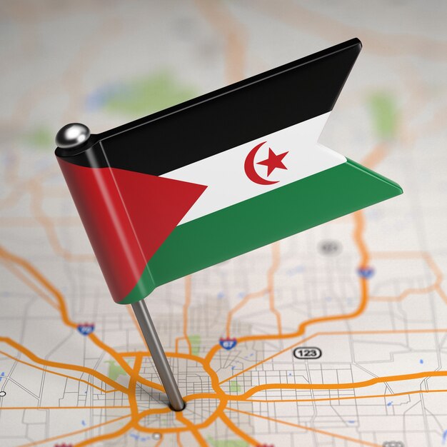 Pequena bandeira da República Democrática Árabe Sahrawi em um fundo de mapa com foco seletivo.