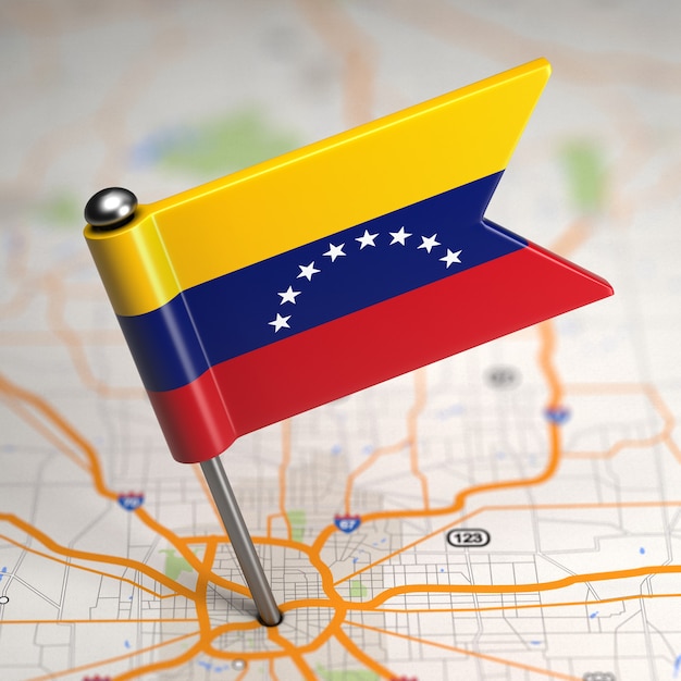 Pequena bandeira da venezuela em um fundo de mapa com foco seletivo.