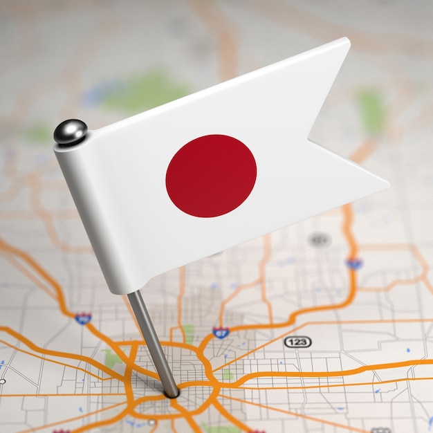 Foto pequeña bandera de japón pegada en el fondo del mapa con enfoque selectivo.