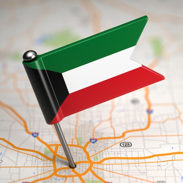 Pequeña bandera de Kuwait sobre un fondo de mapa con enfoque selectivo.