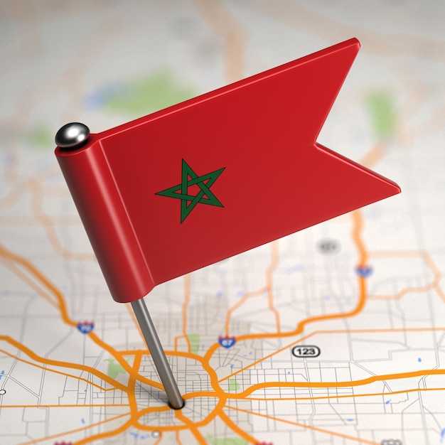 Foto pequeña bandera de marruecos sobre un fondo de mapa con enfoque selectivo.