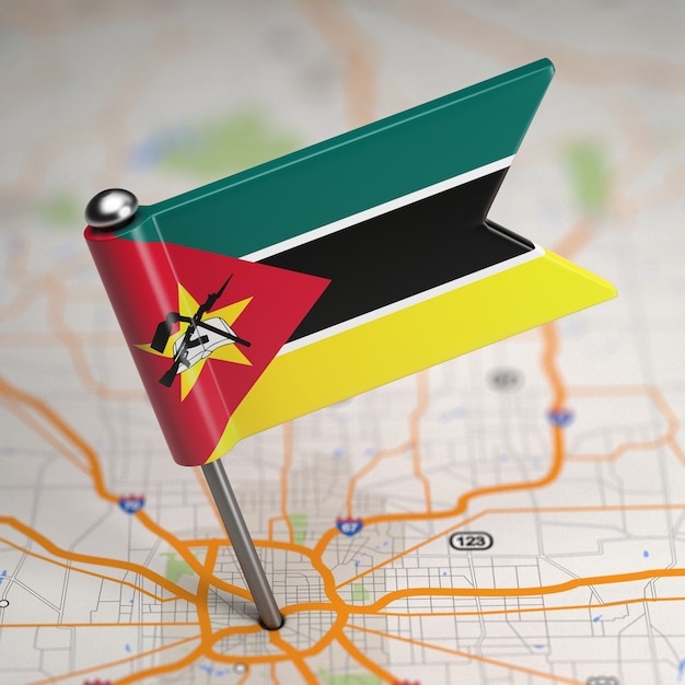 Pequeña bandera de Mozambique sobre un fondo de mapa con enfoque selectivo.