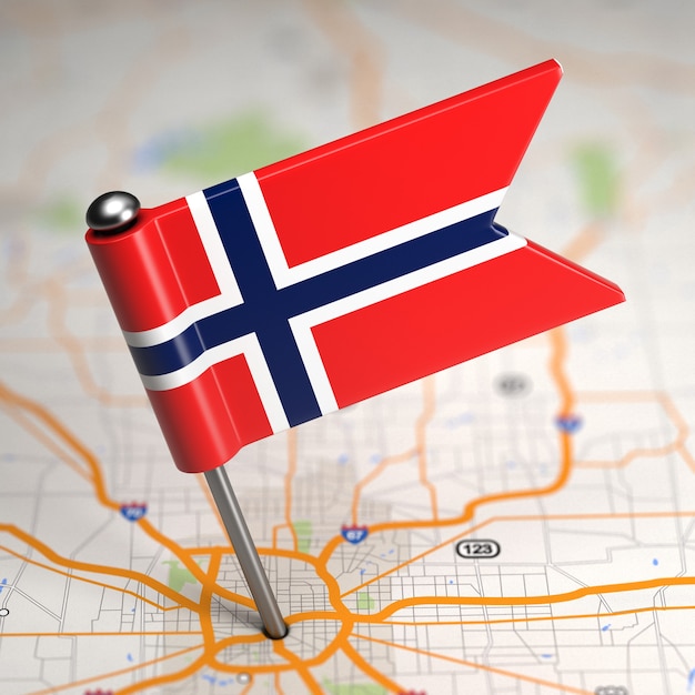 Pequeña bandera de Noruega pegada en el fondo del mapa con enfoque selectivo.