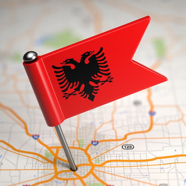 Pequeña bandera de la República de Albania pegada en el fondo del mapa con enfoque selectivo.