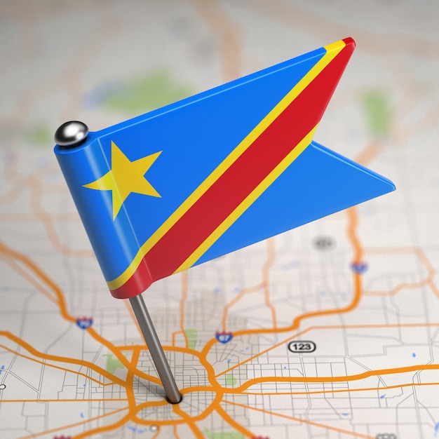 Pequeña bandera de la República Democrática del Congo sobre un fondo de mapa con enfoque selectivo.