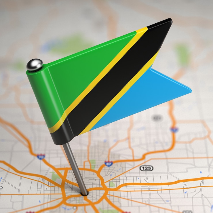 Foto pequeña bandera de tanzania sobre un fondo de mapa con enfoque selectivo.