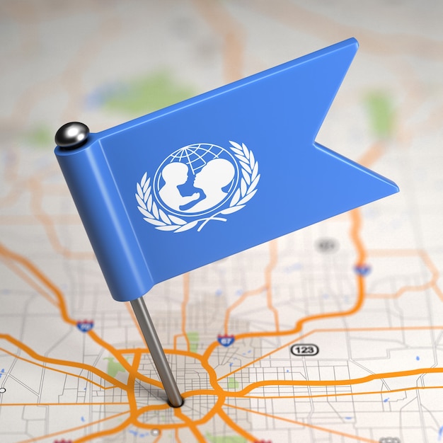 Pequeña bandera de UNICEF sobre un fondo de mapa con enfoque selectivo.