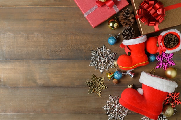 Pequeña bota de santa claus con decoraciones y cajas de regalo en madera