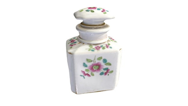 Una pequeña botella blanca con un diseño floral en el frente.