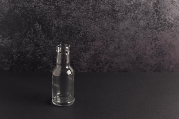Pequeña botella de vidrio sobre un fondo oscuro. concepto de cero residuos