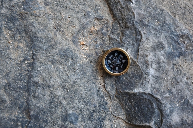 Una pequeña brújula de bolsillo se encuentra en la superficie de piedra