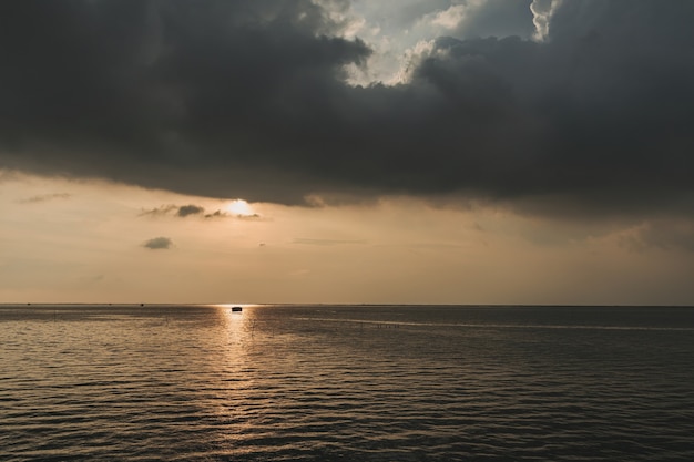 Pequena cabana de pesca no meio do pôr do sol e do mar