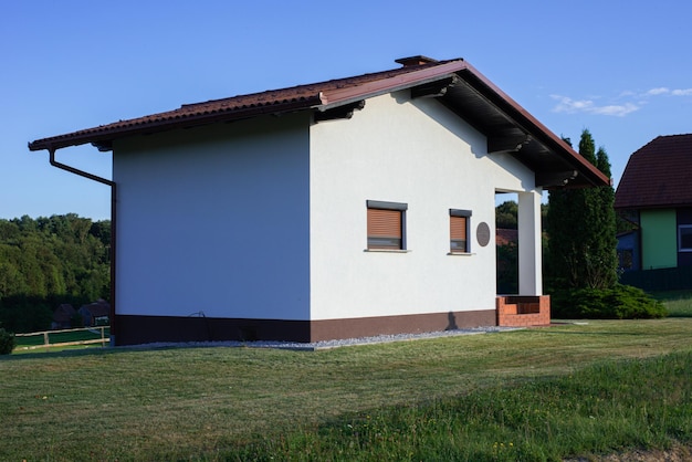 Foto pequeña cabaña encalada sobre césped en el pueblo alpino