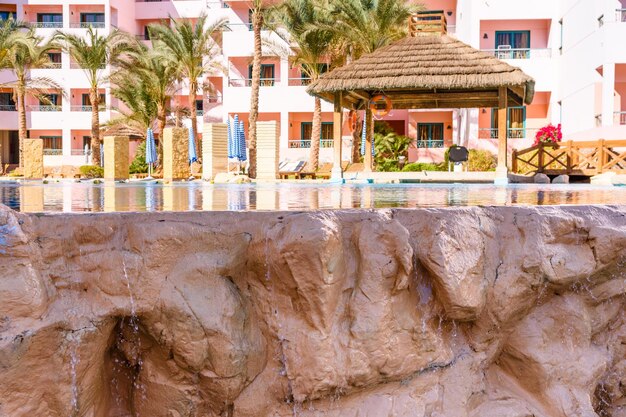 Pequena cachoeira com água turquesa na piscina do hotel