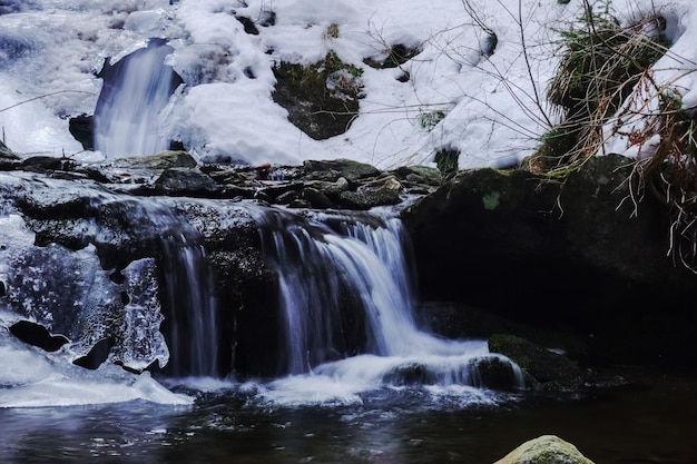 Pequena cachoeira com gelo e neve no inverno