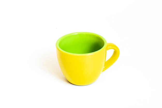 Pequena caneca de café amarela e verde cerâmica vazia xícara de café isolada