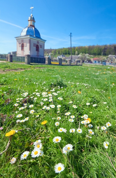 Pequeña capilla campestre en el claro de la flor de primavera