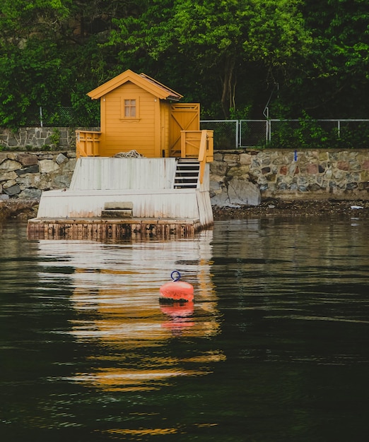 Foto pequena casa amarela colorida e cais no fiorde de oslo na noruega