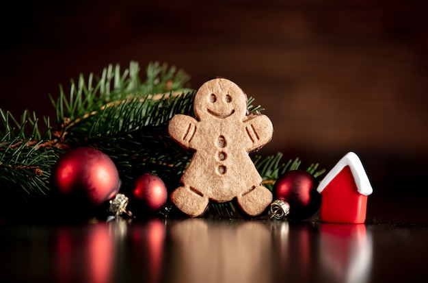 Pequena casa brinquedo e homem-biscoito na mesa de madeira