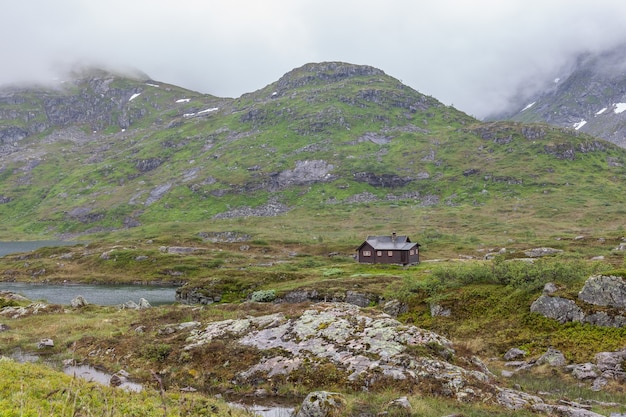 Pequeña casa en una colina en las montañas de noruega.