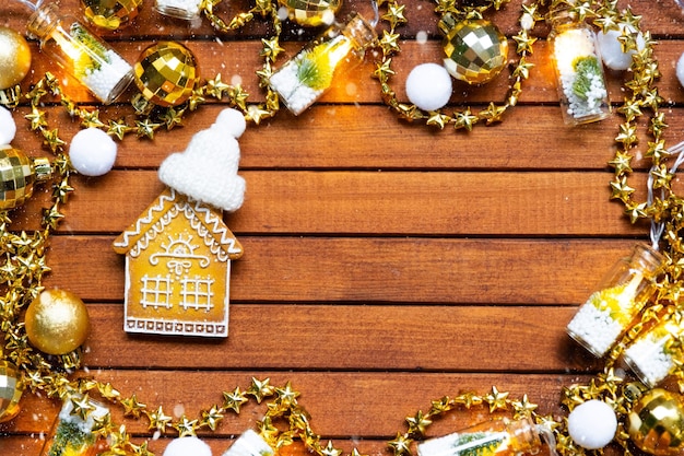 Pequena casa de pão de gengibre em fundo de madeira com layout de decoração de Natal e copy spaceestate