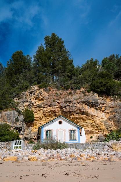 Una pequeña casa está metida en un acantilado, con la palabra "mar" en el fondo.