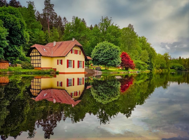 Pequeña casa en un lago en el bosque