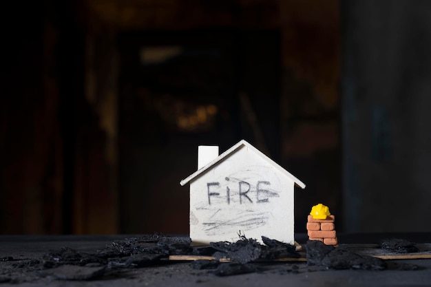 Pequeña casa de madera de ladrillos rojos con las consecuencias del incendio en el fondo