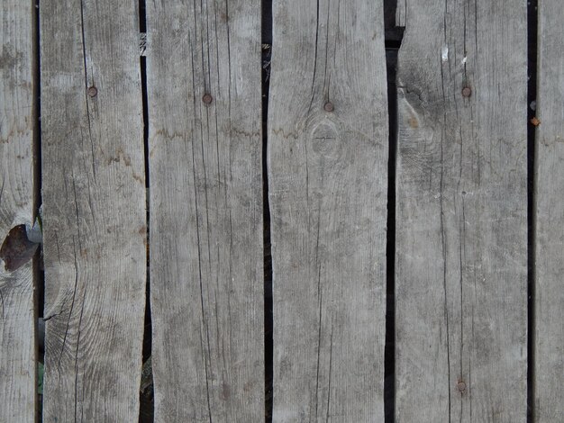 Pequeña casa de madera en la mano de un hombre sobre un fondo amarillo