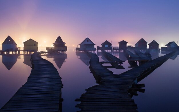 una pequeña casa de madera con una puesta de sol en el fondo