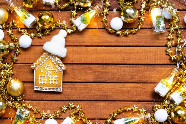 Pequeña casa de pan de jengibre en fondo de madera con diseño de decoración navideña y copia de espacio