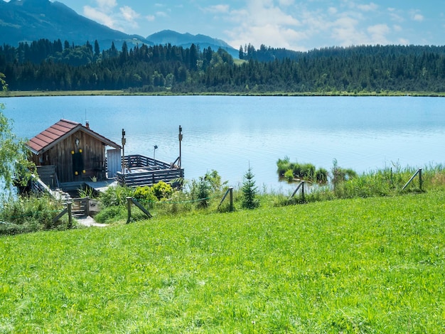 Pequeña casa de pescadores con muelle y terraza en el lago bávaro Attlesee cerca de la ciudad de Nesselwang