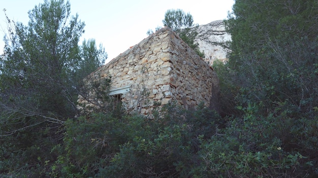 Pequeña casa de piedra vieja en las montañas de España en el bosque, piedra vieja