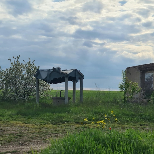 Una pequeña casa con el techo roto se asienta en un campo.