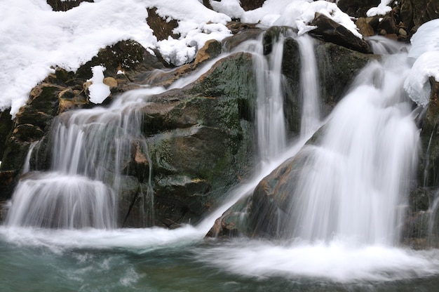 una pequeña cascada activa corriente de montaña limpia paisaje de invierno nevado fondo de vida silvestre