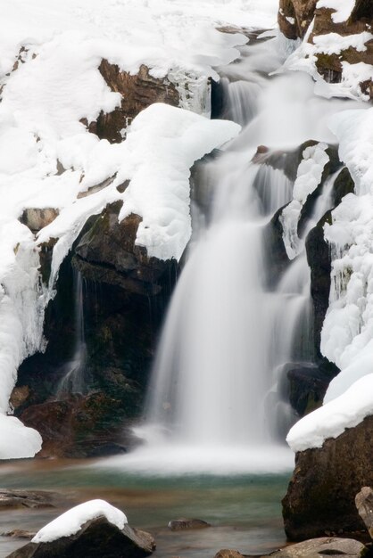 una pequeña cascada activa corriente de montaña limpia paisaje de invierno nevado fondo de vida silvestre