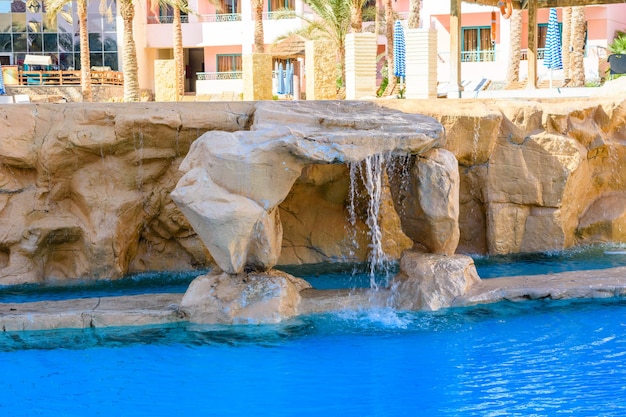 Pequeña cascada de agua turquesa en la piscina del hotel