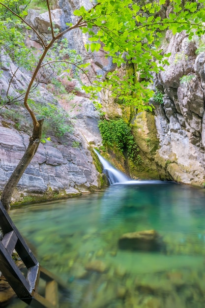 Una pequeña cascada pintoresca en una acogedora laguna de montaña.