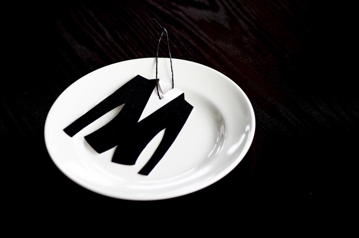 Foto la pequeña chaqueta está cortada de papel de terciopelo en el plato que se encuentra sobre un fondo de madera oscura
