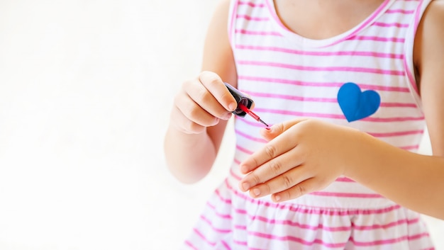 Pequeña chica de moda. Chica hace su maquillaje y manicura. enfoque selectivo