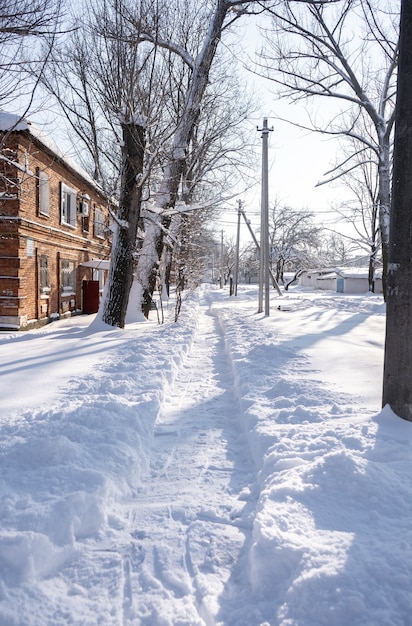 Pequeña ciudad cubierta de nieve. Pequeños edificios y casas en invierno con mucha nieve en la calle.