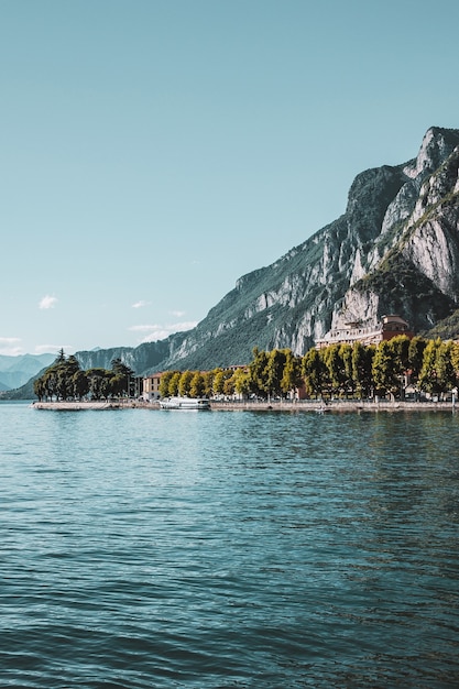 Foto pequeña ciudad con el muelle de la costa del lago de como en italia hermoso paisaje de montaña