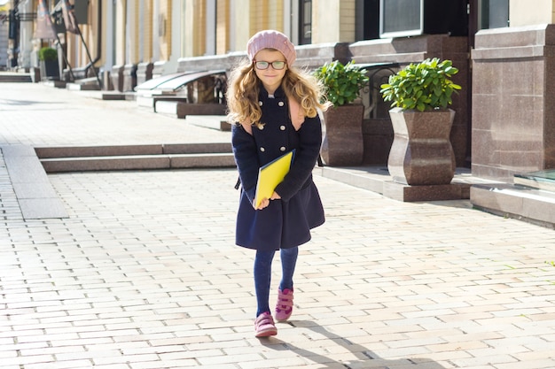 pequeña colegiala adorable con cuadernos