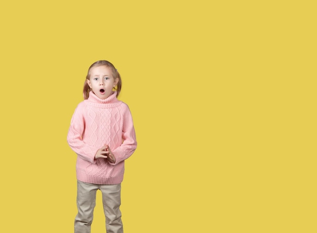 Pequeña colegiala caucásica de edad elemental sorprendida mirando a la cámara