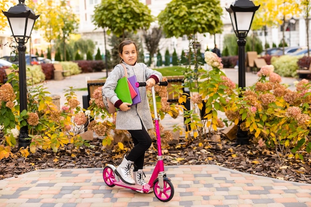 pequeña colegiala en otoño.