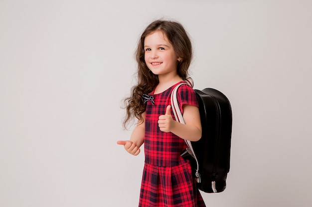 pequeña colegiala sonriendo y pulgares arriba