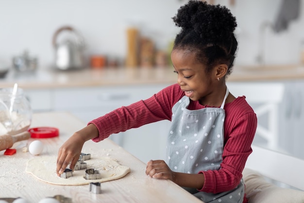 Pequena cozinheira linda garota negra fazendo biscoitos